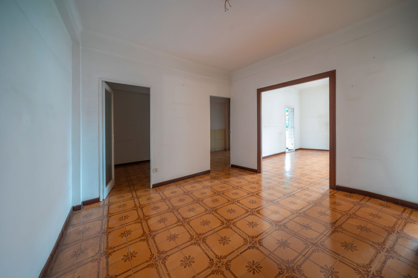 Zona de día antes de la reforma, compartimentada mediante paredes y diferentes pasos entre habitaciones.