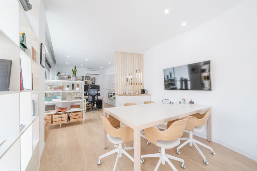 Mesa de reuniones de madera y estanterías en el despacho de arquitectura