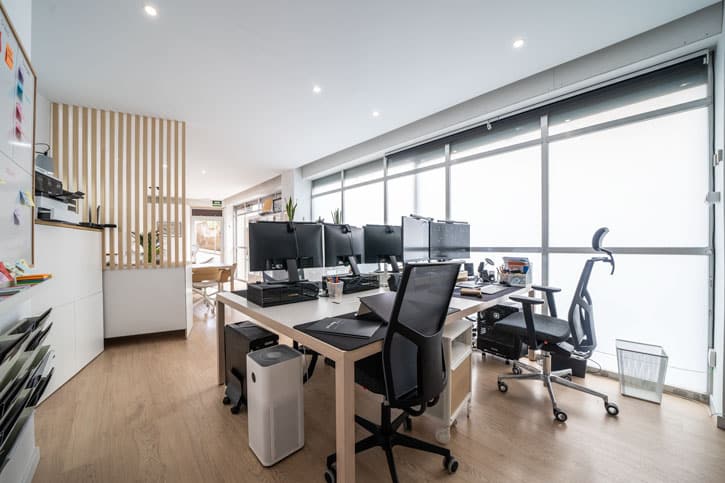 Puestos de trabajo del estudio de arquitectura junto a los grandes ventanales