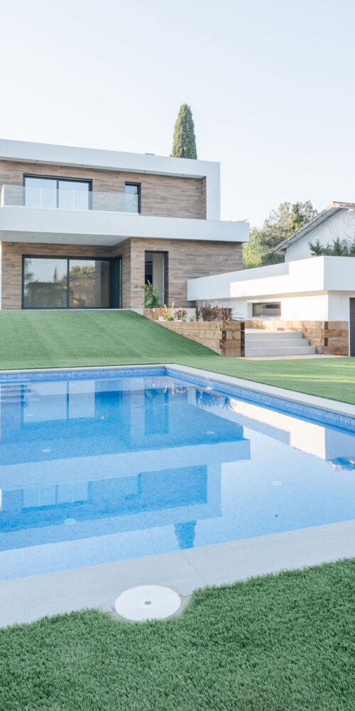 Casa moderna con piscina, jardín y garaje integrado en el desnivel